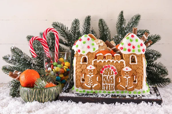 木板上有漂亮的姜饼屋 雪和白色木制背景的食物 — 图库照片