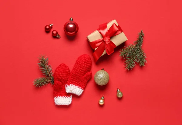 Komposition Mit Geschenkbox Weihnachtsdekoration Und Fäustlingen Auf Rotem Hintergrund — Stockfoto