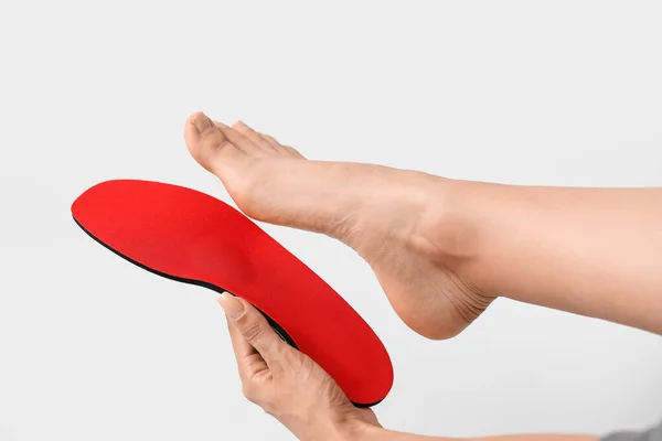 Woman Fitting Red Orthopedic Insole Light Background — Stock Photo, Image