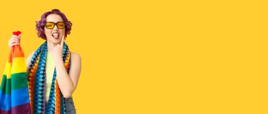 Sarı arkaplanda LGBT bayrağı olan havalı genç bir kadın.