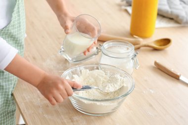 Genç kız mutfakta hamur hazırlıyor, yakın plan.