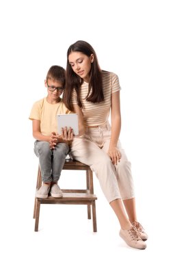 Küçük çocuk ve ablası beyaz arka planda tablet bilgisayar kullanıyorlar.