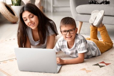 Küçük çocuk evde ablasıyla dizüstü bilgisayar kullanıyor.