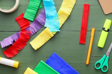 Yeşil ahşap arka planda renkli Meksika pinyatası yapmak için malzemeler