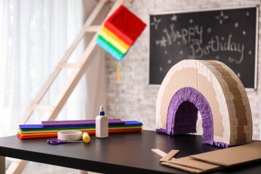 Odada gökkuşağı şeklinde Meksika pinyatası yapmak için malzemeler.