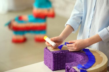 Masada gökkuşağı şeklinde Meksika pinyatası yapan kadın.