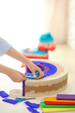 Masada gökkuşağı şeklinde Meksika pinyatası yapan kadın.