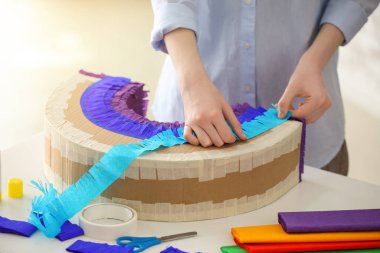 Masada gökkuşağı şeklinde Meksika pinyatası yapan kadın.