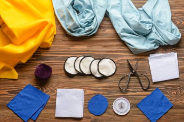 Koyu ahşap arka planda malzeme içeren el yapımı pamuk pedler.