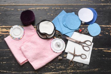 Koyu ahşap arka planda materyalleri olan el yapımı yeniden kullanılabilir pamuk yastıklar.