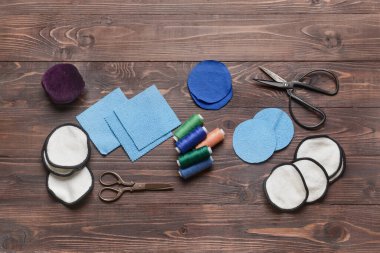 Koyu ahşap arka planda materyalleri olan el yapımı yeniden kullanılabilir pamuk yastıklar.