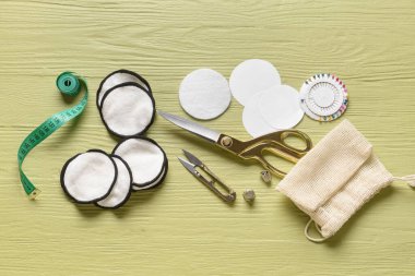 Renkli ahşap arka planda malzeme içeren el yapımı pamuk pedler.