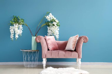 Masalı rahat bir koltuk ve mavi duvarın yanında güzel bir dekor.