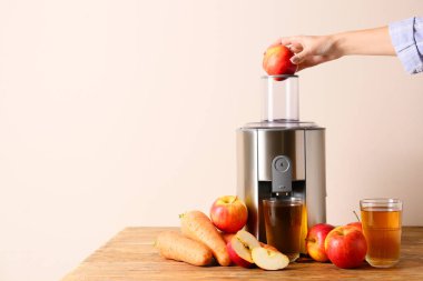 Kadın masada taze meyve suyu yapıyor.