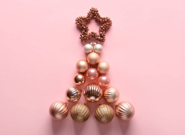 Pembe arka planda güzel süslerden yapılmış Noel ağacı