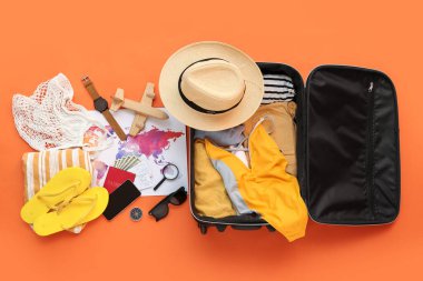 Dolu plaj aksesuarları ve renk arkaplan üzerinde dünya haritası olan bavul