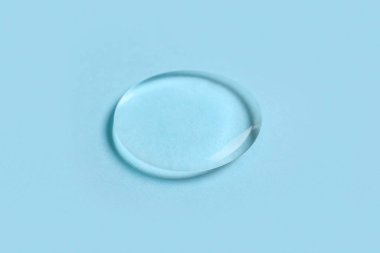 Mavi arkaplanda sıvı şeffaf jel damlası