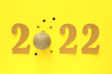 2022 ve sarı arka planda Noel topu.