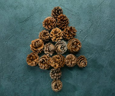 Koyu arkaplanda çam kozalaklarından yapılmış ağaç