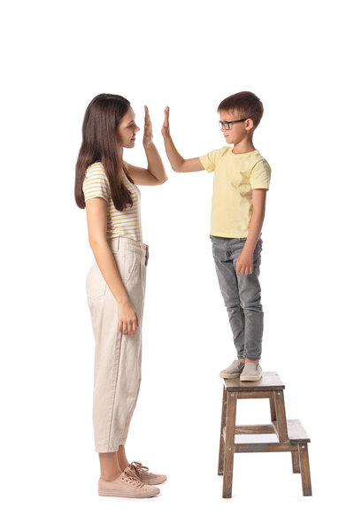 Teenage girl and her little brother giving each other high-five on white background