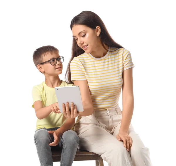 Küçük çocuk ve ablası beyaz arka planda tablet bilgisayar kullanıyorlar.