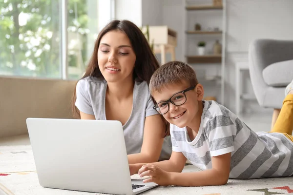 Küçük çocuk evde ablasıyla dizüstü bilgisayar kullanıyor.