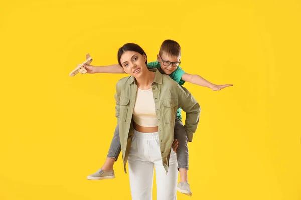 Teenage Girl Carrying Pickaback Her Little Brother Wooden Airplane Yellow — Stock Photo, Image