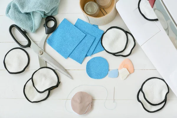 Beyaz ahşap arka planda yeniden kullanılabilir pamuk pedleri yapmak için malzemeler