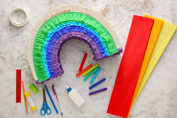 Arkaplanda gökkuşağı şeklinde Meksika pinyatası yapmak için malzemeler