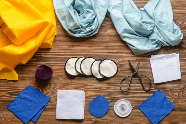 Koyu ahşap arka planda malzeme içeren el yapımı pamuk pedler.