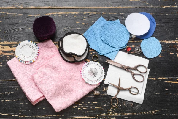 Koyu ahşap arka planda materyalleri olan el yapımı yeniden kullanılabilir pamuk yastıklar.