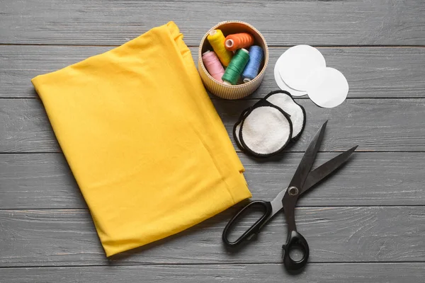 Koyu ahşap arka planda malzeme içeren el yapımı pamuk pedler.