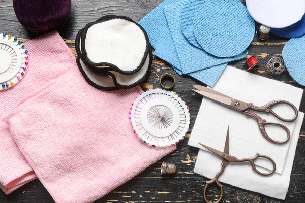 Koyu ahşap arka planda materyalleri olan el yapımı yeniden kullanılabilir pamuk yastıklar.