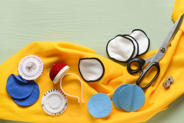 Yeşil ahşap arka planda malzeme içeren el yapımı pamuk pedler.