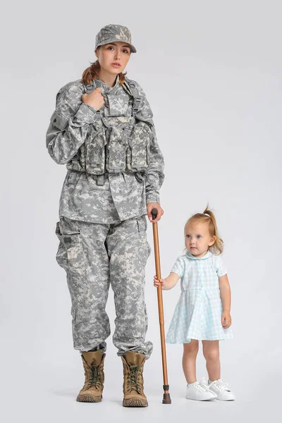 Kvinna Soldat Med Käpp Och Hennes Lilla Dotter Ljus Bakgrund — Stockfoto