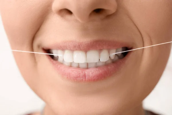 Wanita Dengan Benang Gigi Pada Latar Belakang Putih Closeup — Stok Foto