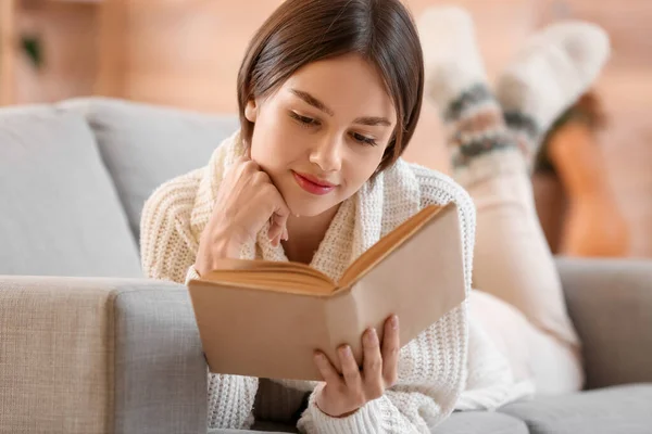 Όμορφη Νεαρή Γυναίκα Ανάγνωση Βιβλίο Στον Καναπέ Στο Σπίτι — Φωτογραφία Αρχείου