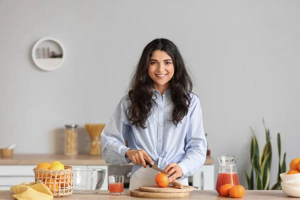 年轻女子在厨房切柑橘类水果做鲜果汁 — 图库照片
