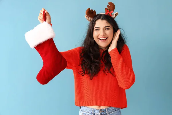 幸せな若いです女性とともにクリスマスソックス上の色背景 — ストック写真