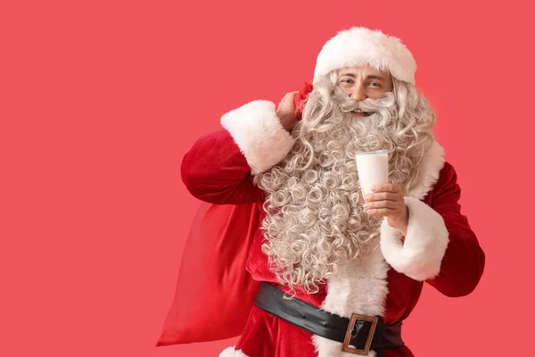 Санта Клаус Стаканом Молока Мешком Красном Фоне — стоковое фото