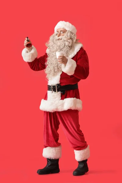 Kerstman Met Glas Melk Kerstbel Rode Achtergrond — Stockfoto