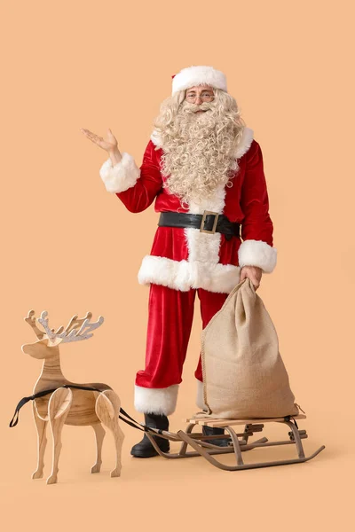 Weihnachtsmann Mit Sacksack Schlitten Und Holz Rentieren Auf Beigem Hintergrund — Stockfoto