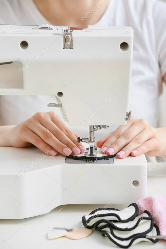 Woman sewing reusable cotton pad at table, closeup