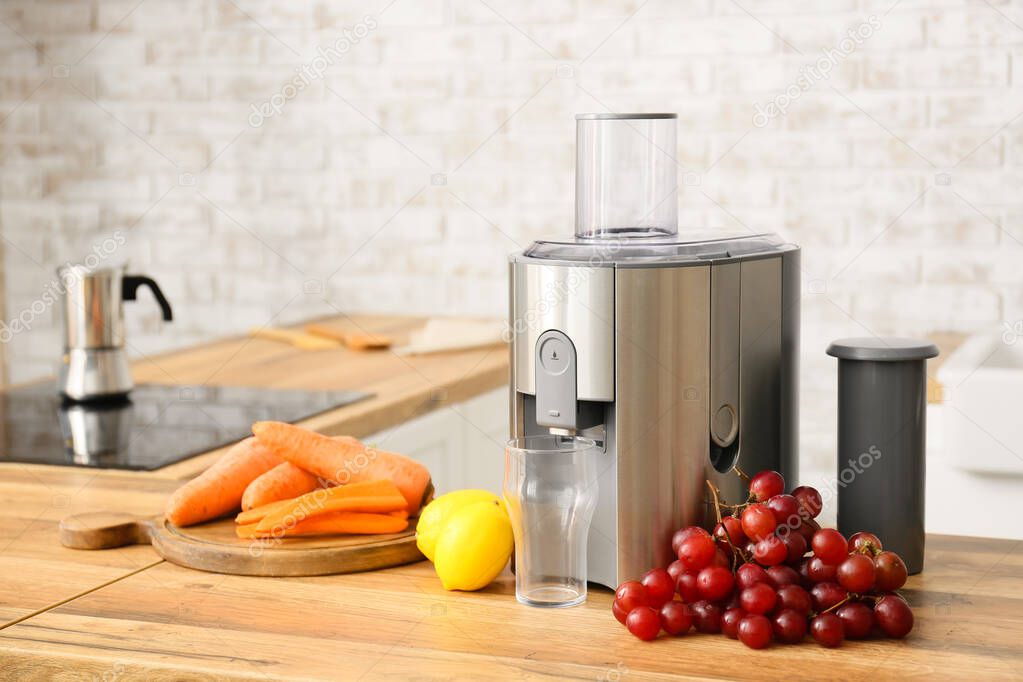 Modern juicer with fresh fruits on table in kitchen
