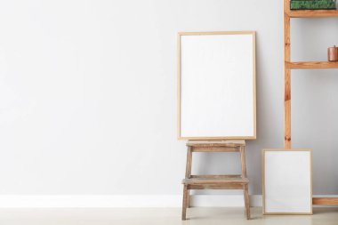 Merdivende boş poster ve ışık duvarının yanında dekor var.