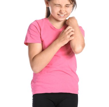 Küçük kız beyaz arka planda kendini tırmalıyor.