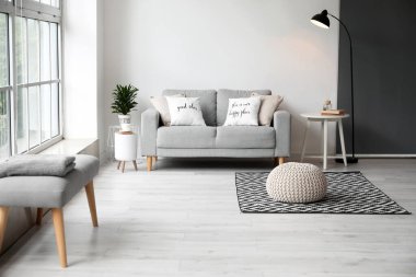 Masası, kanepesi ve puf olan ışık odasının içinde.