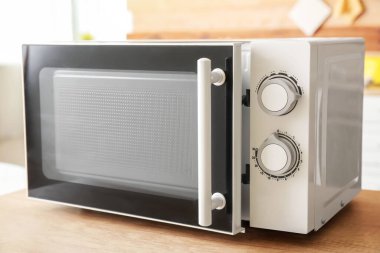 Mutfaktaki ahşap masa üstünde mikrodalga fırın.