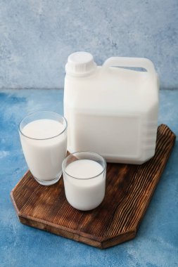 Renkli arka planda galon şişe ve bir bardak süt