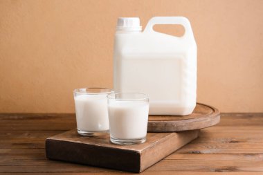 Tahta masada bir şişe ve bir bardak süt.